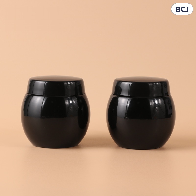 กระปุกครีมแก้วดำเงา ทรงท้องกลม BCJ 50 / 100 กรัม – กระปุกครีมแก้วดำเงา ทรงท้องกลม วางเคียงกัน เห็นรูปทรงป่องกลางตัว ฝาเกลียวแบนขอบมน
