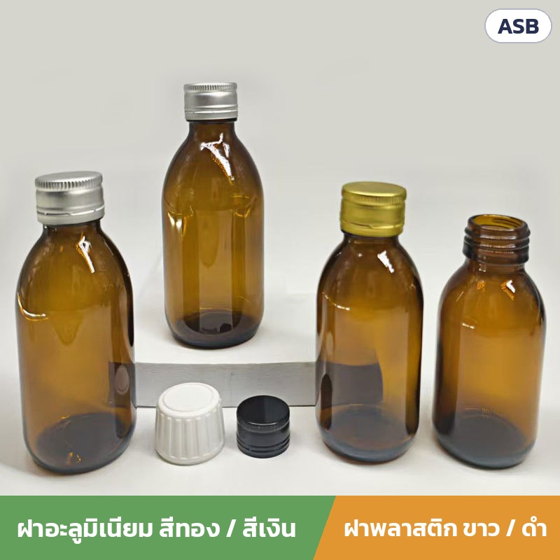 ขวดยาน้ำแก้วสีชา ฝาเกลียว ASB – ขวดสวมฝาอะลูมิเนียมสีเงินและสีทอง ขวดเปิดปากเห็นเกลียว และฝาพลาสติกเซฟตี้สีขาว/สีดำวางข้างขวด